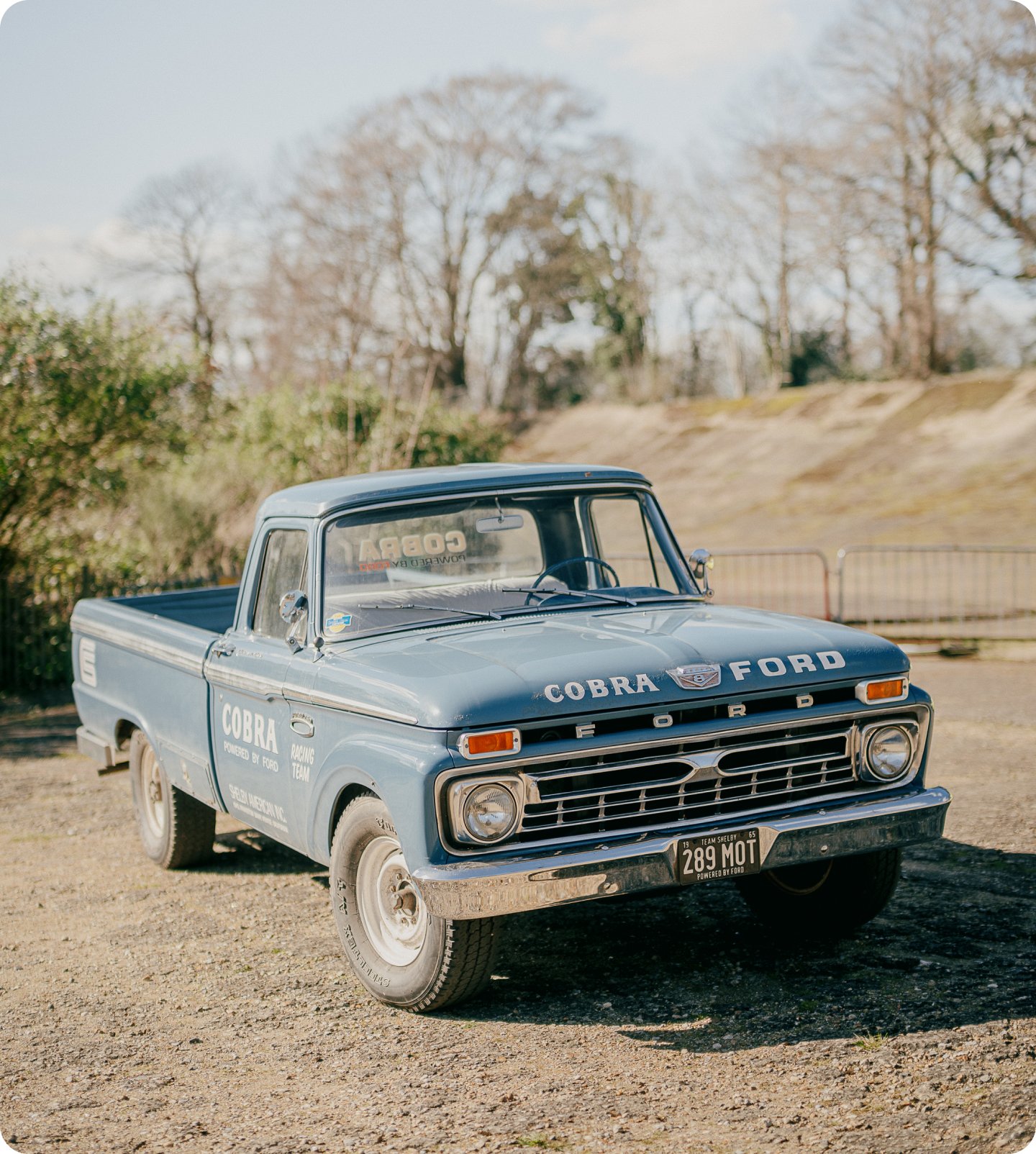 A close up of the front of a classic Yellow BMW, showing the badge in detail