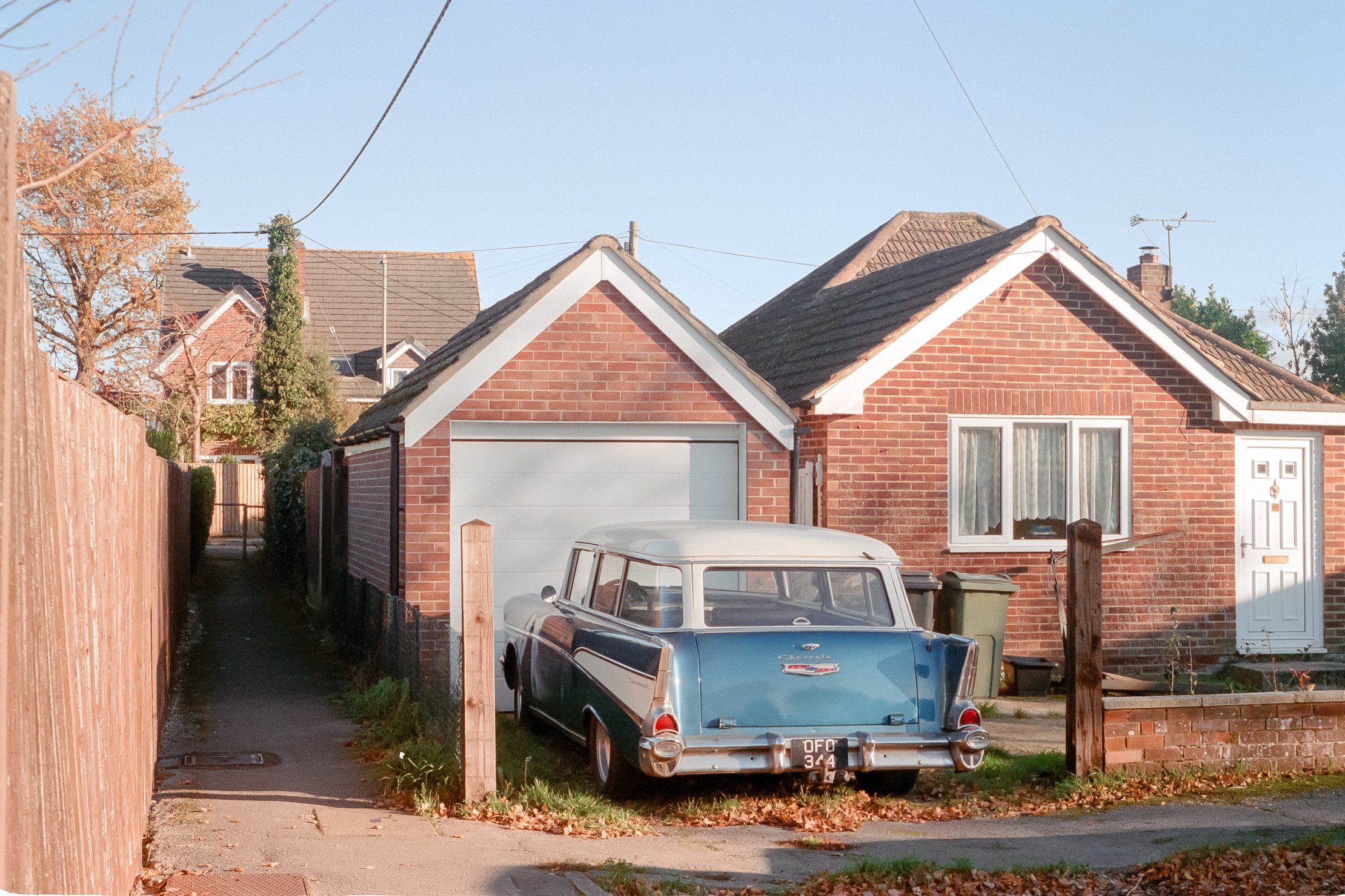A vintage car parked outside a house
